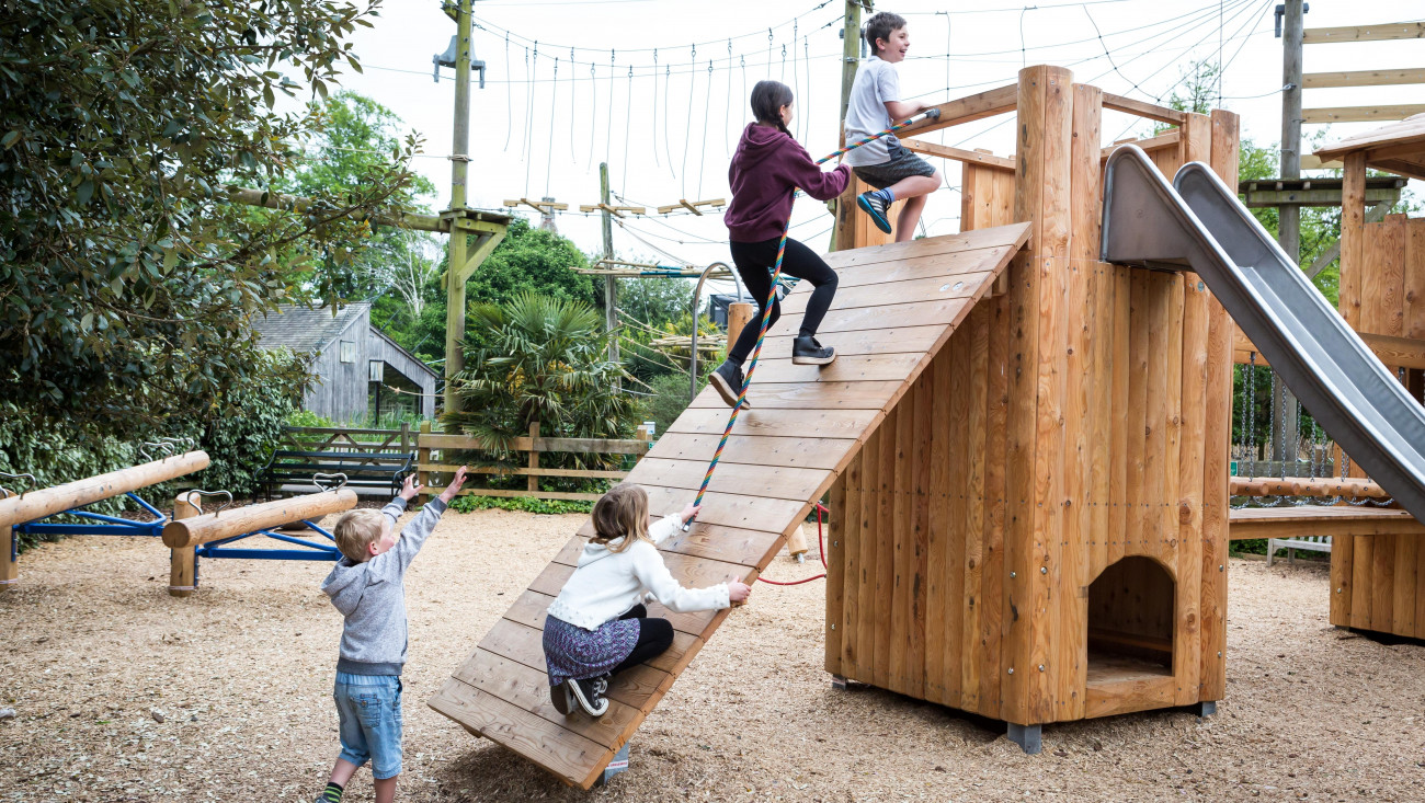 Young kids playing on a wooden tower